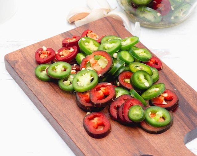 Chilipflanze mit zahlreichen reifen und unreifen Schoten am Strauch
