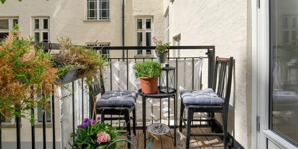 Kleiner Balkon mit Pflanzen, Sitzplätzen und Tisch