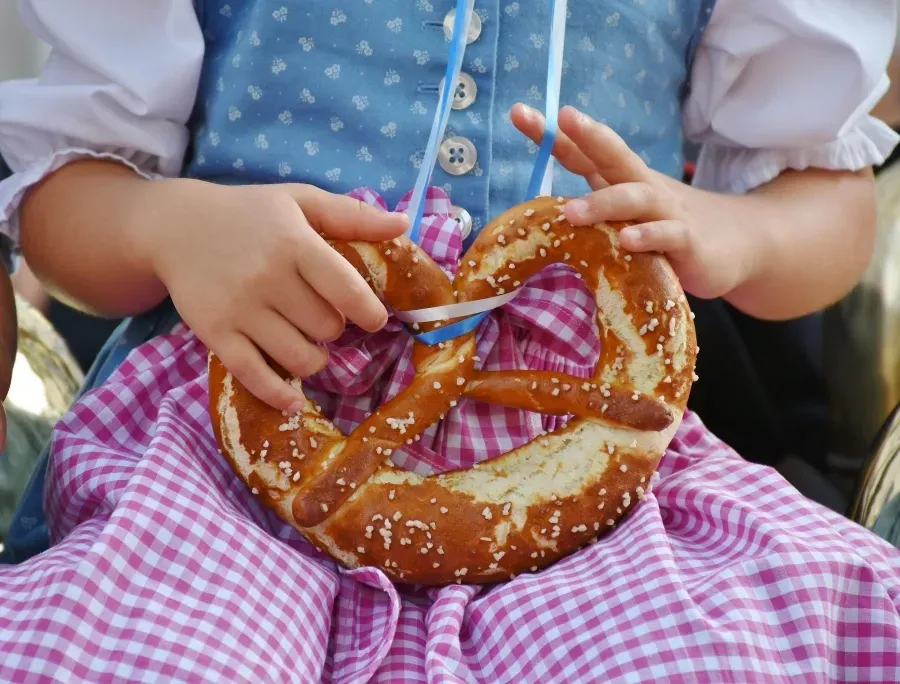 Kinderhände halten eine Laugenbrezel mit Salz