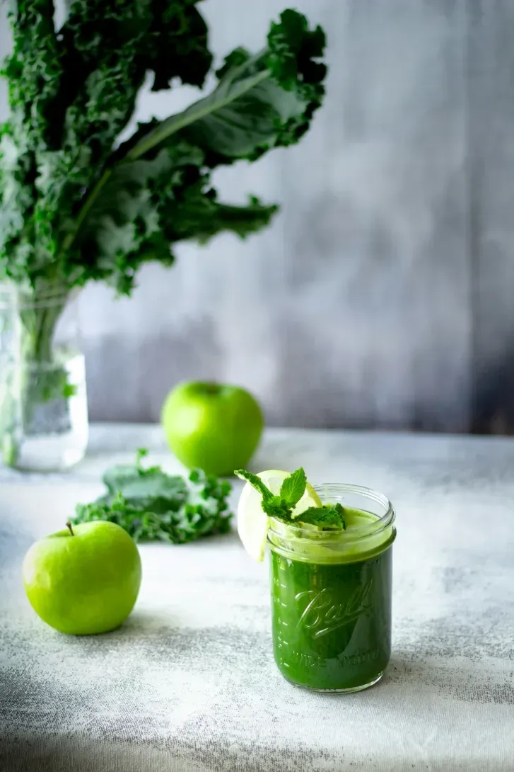 Grüner Smoothie mit Grünkohl und Apfel im Glas